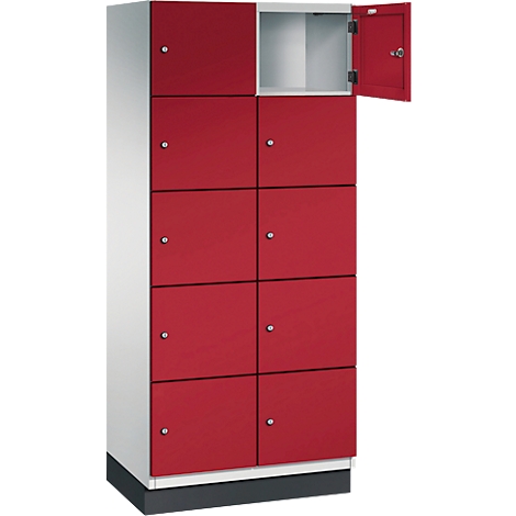 Rote Schrankwand, eine Tür geöffnet, silberne Knöpfe. Grauer Sockel, weißer Rahmen.