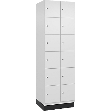 Ein weißer Schrank mit mehreren Fächern und silberfarbenen Griffen. Auf schwarzem Sockel stehend.