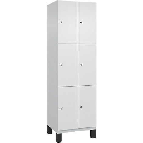 Weisser Schrank mit sechs Türen. Jede Tür hat einen kleinen runden Knopf. Der Schrank steht auf schwarzen Füssen.