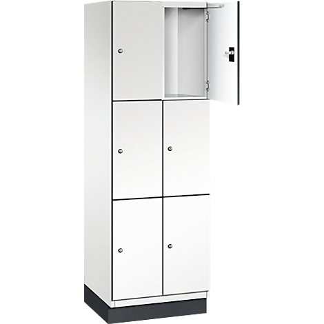 Weisser Schrank mit sechs Türen, eine davon geöffnet. Die Türen sind mit kleinen Knöpfen und einem Schlüsselloch versehen.