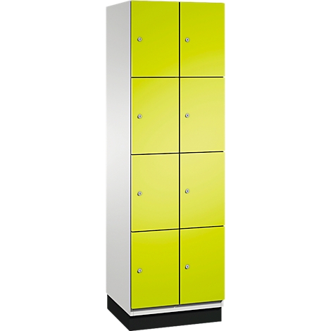 Ein hoher Schrank mit acht gelbgrünen Türen, jeweils mit einem silbernen Knopf. Der Korpus ist weiß, der Sockel schwarz.