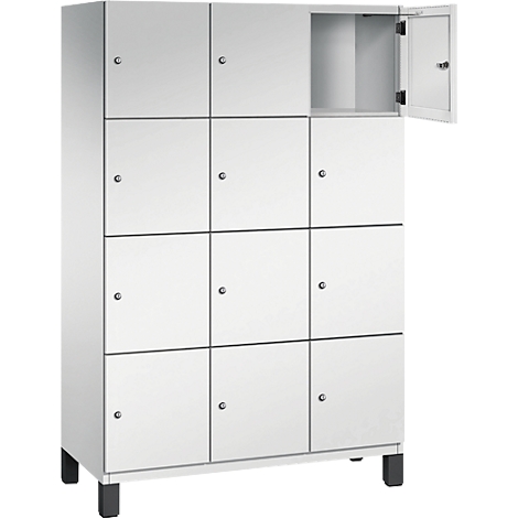 Weißer Spind mit 12 Fächern, eins geöffnet.
