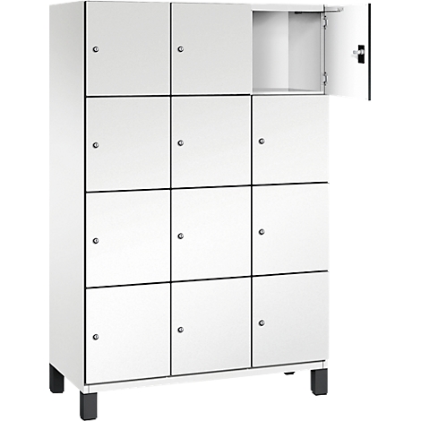 Weißer Spind mit mehreren Fächern. Eine Tür ist geöffnet.