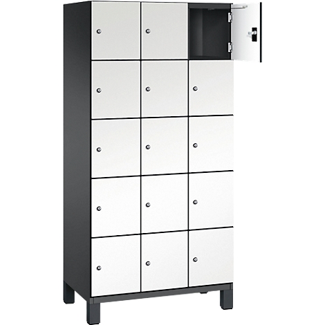 Ein weiß-grauer Spind mit 12 Türen, eine ist geöffnet. Schwarzer Rahmen und Füße.