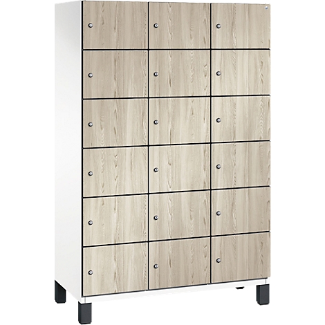 Schrank mit Holzoptik, 15 Fächer, Metallgriffe. Steht auf schwarzen Füßen, weißer Rahmen.