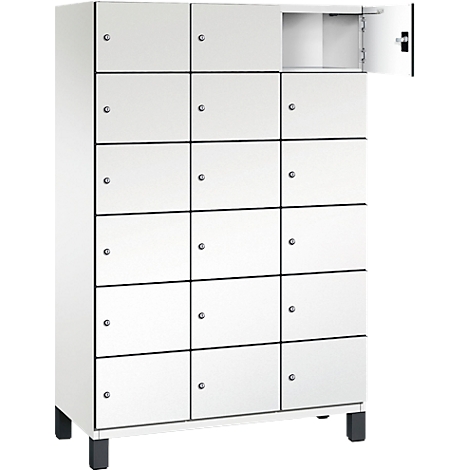 Weißer Schrank mit mehreren Fächern. Eine Tür ist geöffnet, daneben ist ein Metallgriff.