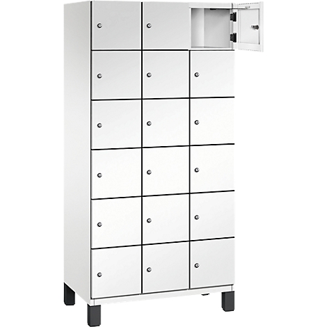Weißer Spind mit 15 Fächern, ein Fach geöffnet.