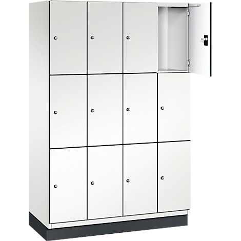 Weißer Schrank mit 12 Fächern. Ein Fach ist geöffnet. Der Schrank steht auf einem schwarzen Sockel. Schwarze Linien trennen die Türen.