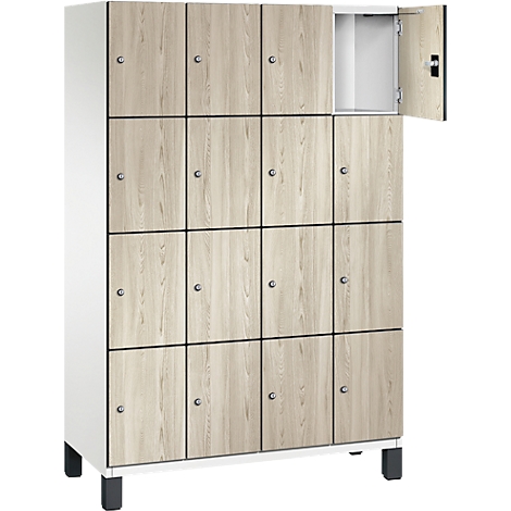 Schrank mit 16 Fächern mit Holzoptik, ein Fach geöffnet. Die Fächer sind mit kleinen Knöpfen und dunklen Rahmen versehen.