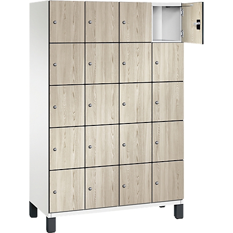 Schrank mit Holztüren, eine davon geöffnet. Schwarze Rahmen um die Türen, silberne Knäufe. Weißer Korpus.