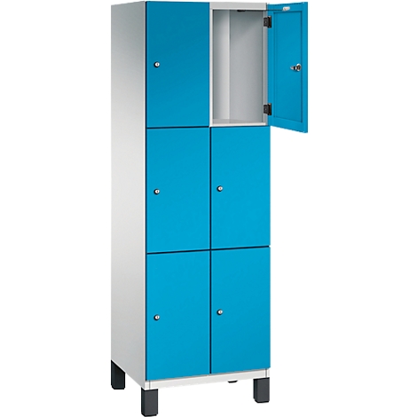 Schrank mit sechs Fächern. Die Türen sind blau, eine Tür ist geöffnet. Der Schrank steht auf schwarzen Füßen.