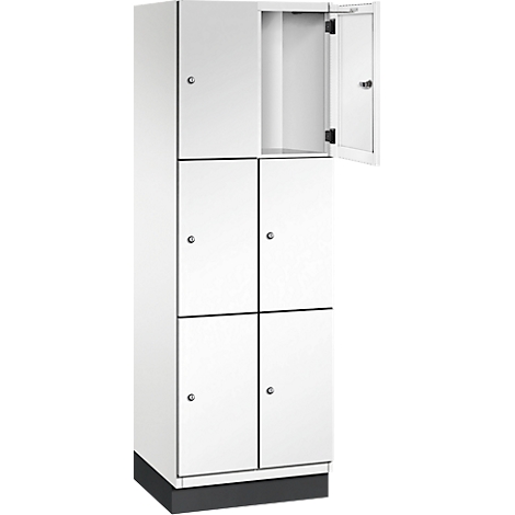 Weißer Spind mit sechs Fächern, eines geöffnet. Die Tür des geöffneten Faches ist nach außen geöffnet.