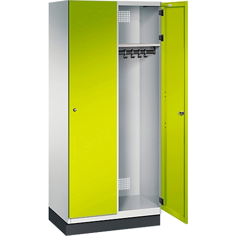 Ein zweitüriger Spind mit gelbgrünen Türen und weißem Korpus. Eine Tür ist geöffnet, Haken innen.