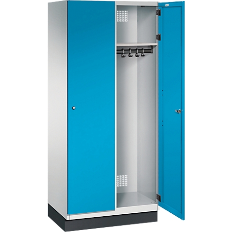 Ein offener blauer Spind, mit Kleiderstange und Ablagefach.