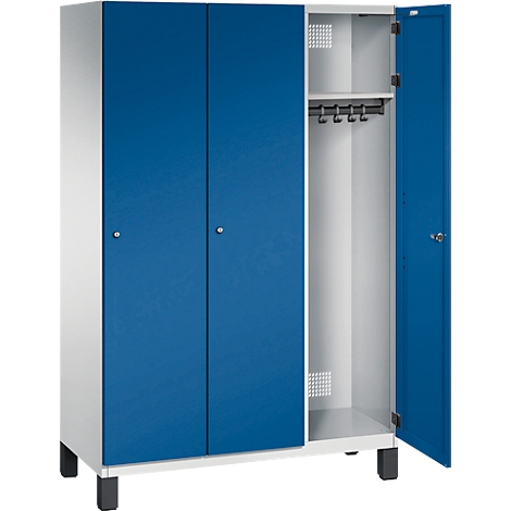 Stahlschrank, weiß, mit blauen Türen. Eine Tür geöffnet, sichtbar ist die Inneneinrichtung mit Kleiderstange.