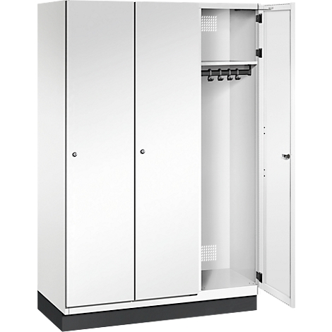 Weißer Spind, eine Tür geöffnet. Innen eine Kleiderstange und ein Regal.