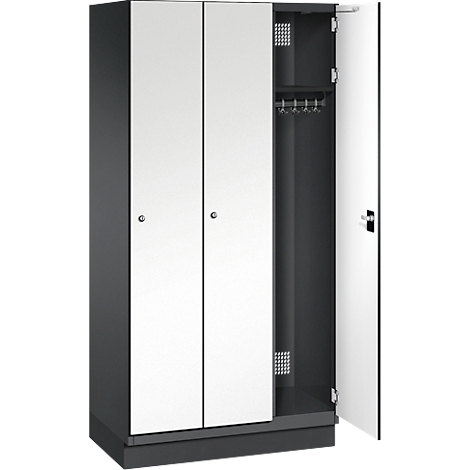 Dreitüriger Schrank, eine Tür geöffnet, mit Kleiderstange und Ablage. Türen weiß, Rahmen grau.