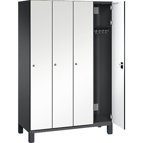 Ein grauer Schrank mit drei Türen und einer geöffneten Tür, in der Kleiderbügel hängen.