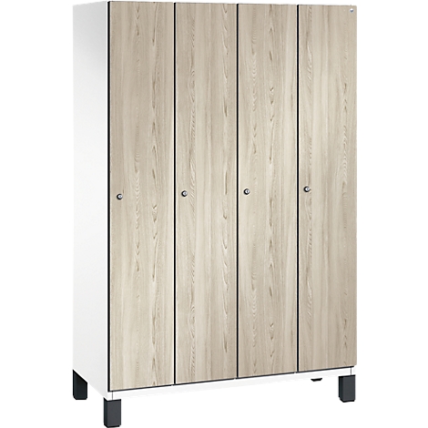 Schrank mit vier Türen aus Holzimitat, helle Farbe mit Maserung. Der Korpus ist weiß, steht auf schwarzen Füßen.