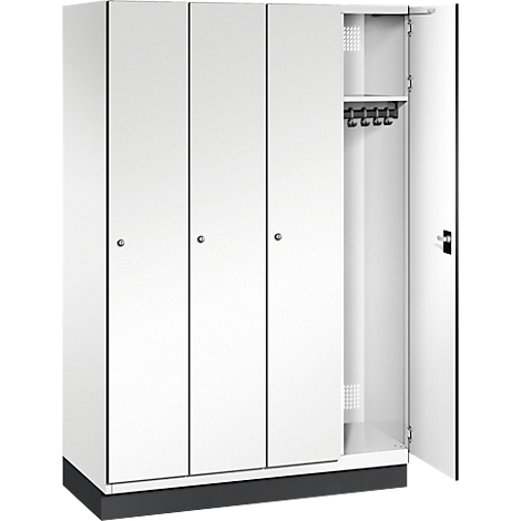 Weißer Spind mit vier Türen, eine Tür ist geöffnet. Im Inneren Haken für Kleidung.