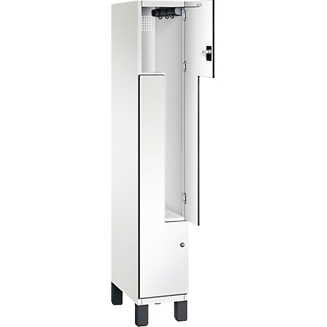 Witte kast, gedeeltelijk open. Binnenin een stang met haken, daarboven ventilatiesleuven, onderste deur met slot.