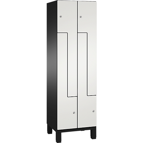 Weißer Schrank mit schwarzem Rahmen und Beinen, Türen mit abgerundeten Kanten und silbernen Griffen.