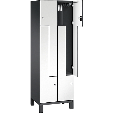 Ein Spind in grau und weiß, mit einer geöffneten Tür, der Innenraum ist sichtbar.