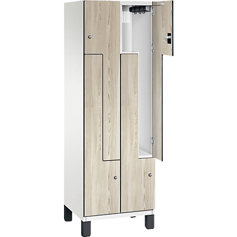 Schrank mit geöffneter Tür. Weiße Seiten, Holztüren, silberfarbene Griffe, schwarze Füße.