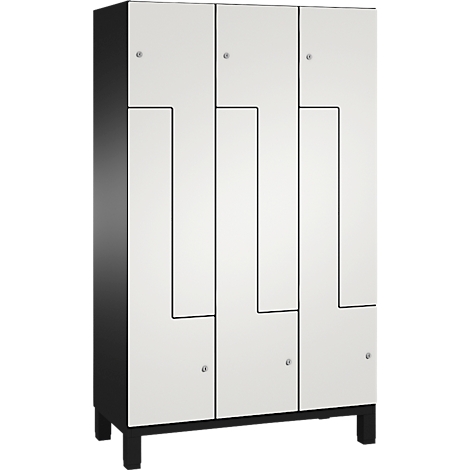 Ein weißer Schrank mit schwarzen Akzenten. Schwarzer Rahmen, Türen mit geometrischen Mustern.