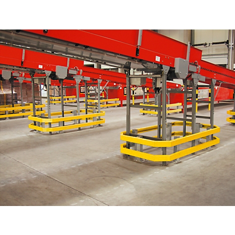 Industrial hall with conveyor belts. Red conveyor belts above yellow protective devices, concrete floor.
