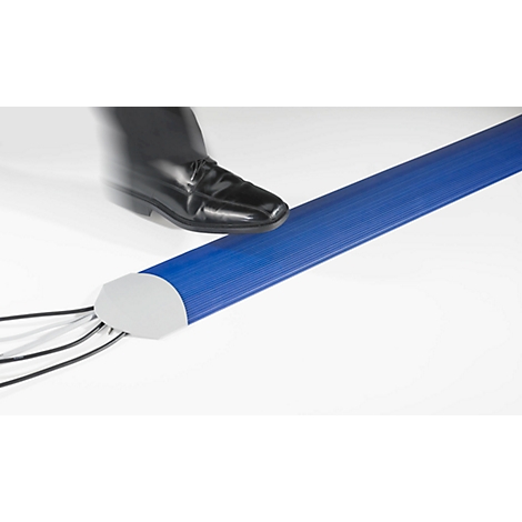 Black shoe stepping on a blue cable duct. Several cables come out of the duct.