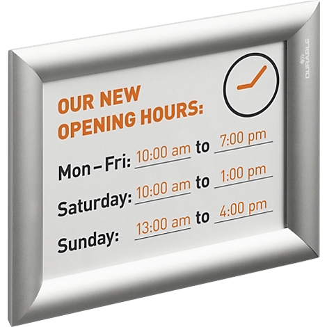 Cadre d'information argenté affichant les horaires d'ouverture, monté sur un mur.