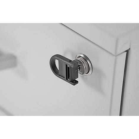 Gros plan d'une clé dans une serrure d'armoire. La clé est insérée dans la serrure argentée, avec une poignée noire.