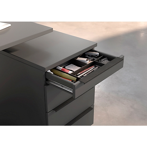 Bureau gris avec tiroir ouvert, rempli de fournitures de bureau.