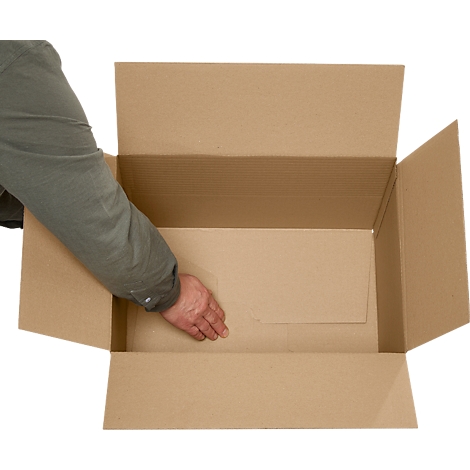 Una mano de una persona alcanza una caja de cartón marrón abierta. Las paredes de la caja son de cartón corrugado.
