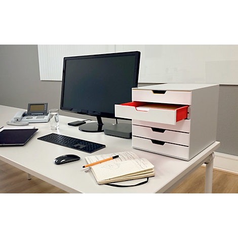 Escritorio con computadora, cajonera, teléfono, bolígrafo y cuaderno. Un cajón está abierto.