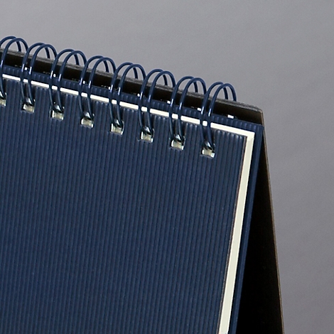 Gros plan sur un calendrier de bureau bleu avec reliure à spirale.