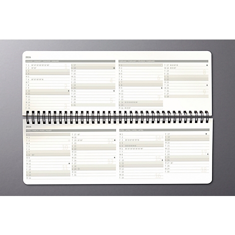 Cahier ouvert avec reliure à spirale. Planification annuelle claire, fond gris.