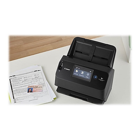 Ein schwarzer Canon-Scanner mit geöffnetem Deckel steht auf einem Schreibtisch. Daneben liegen Papiere und ein Personalausweis.
