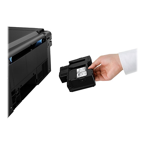 Eine Hand hält eine schwarze Tintenpatrone. Neben einem schwarzen Drucker. Weißer Hintergrund.