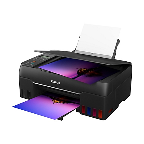 Imprimante Canon noire avec couvercle ouvert. Une feuille de papier sort. Le papier montre une photo avec un paysage violet-bleu imprimé dessus.
