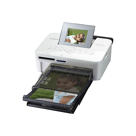 Ein weißer Canon Selphy CP1000 Fotodrucker mit einem hochgeklappten Bildschirm, der ein lächelndes Kind zeigt, und einer herausgezogenen Papierzufuhr mit einem Foto desselben Kindes.