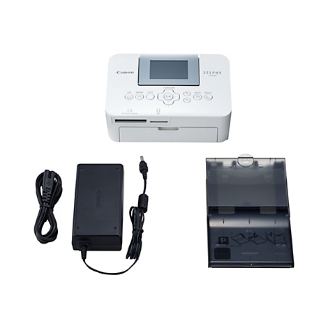 Ein weißer Canon Selphy CP1000 Fotodrucker mit Zubehör: Netzteil, Netzkabel, Papiereinzug. Auf weißem Hintergrund.