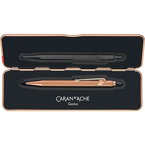 Stifthalter mit zwei Stiften. Ein schwarzer Stift oben, ein roségoldener Stift unten. Beide liegen in einer schwarzen Box. Markenlogo unten.