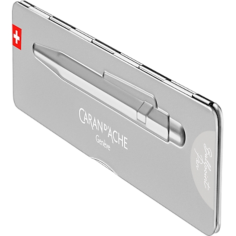 Silberne Stiftbox mit Caran d'Ache Kugelschreiber. Schweizer Kreuz, Schriftzug und "Ballpoint Pen" erkennbar.
