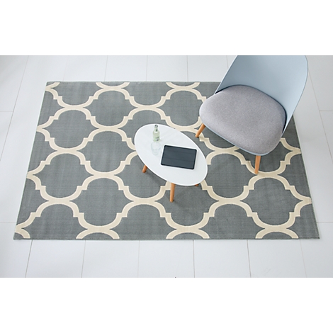 Gray patterned rug, small table with tablet, and chair.