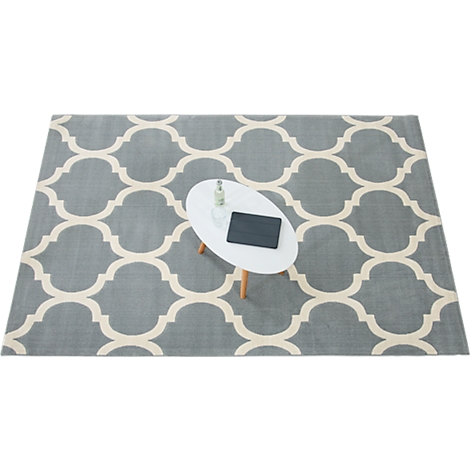 Gray rug with cream pattern, oval table with tablet and bottle.