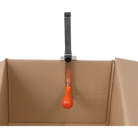 Tool in a cardboard box, with an orange handle and a metal bracket to fix it.