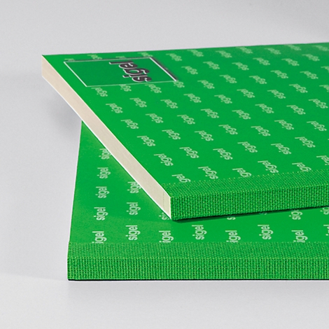 Two green boards with text pattern. The upper board is partially placed on the lower one, the sides show a white and green structure.