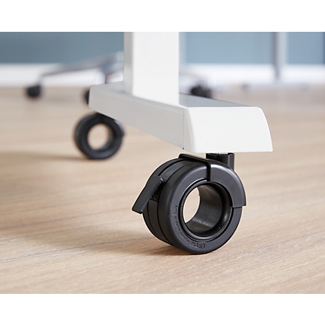 Close-up of a black office chair wheel with brake on a white chair leg. The floor is light brown.